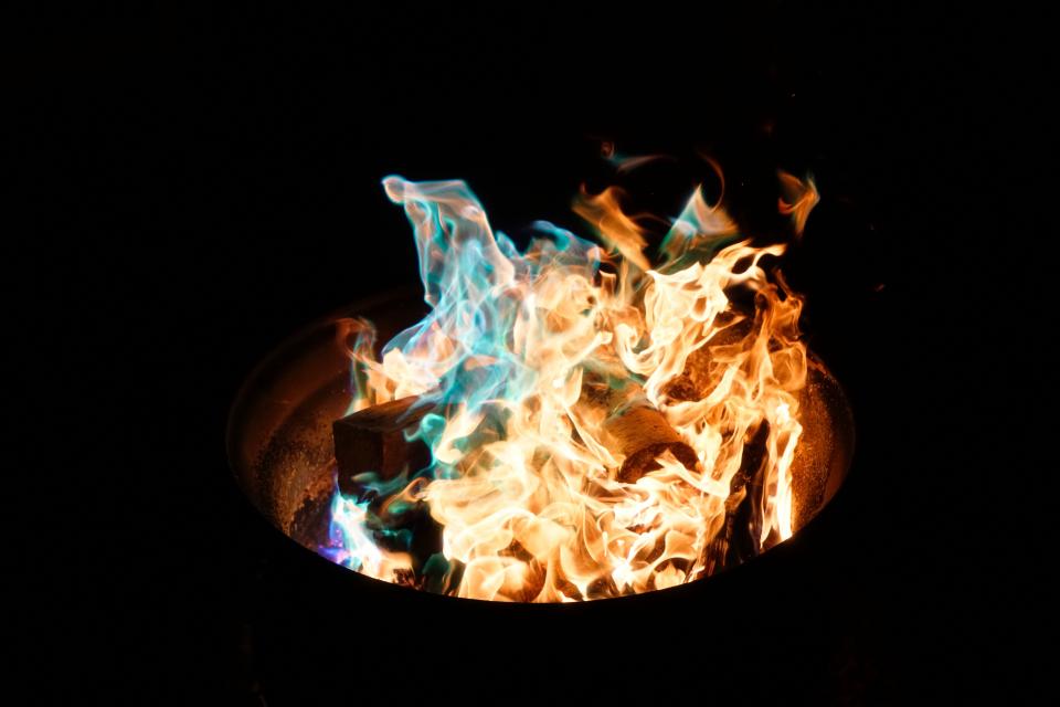 fire pit with burning wood logs and colorful flames