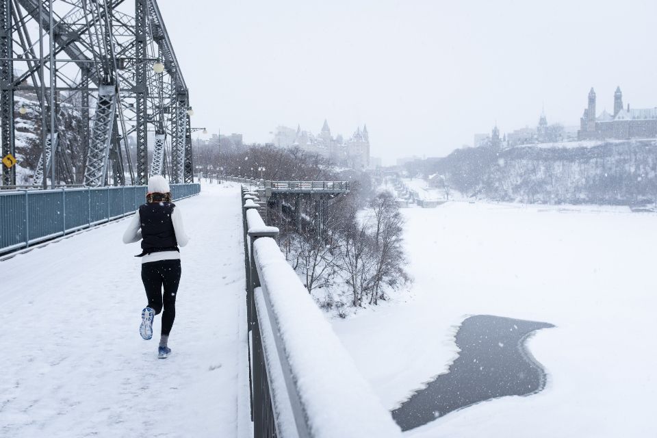 woman wearing exercises by running in the urban landscape during winter