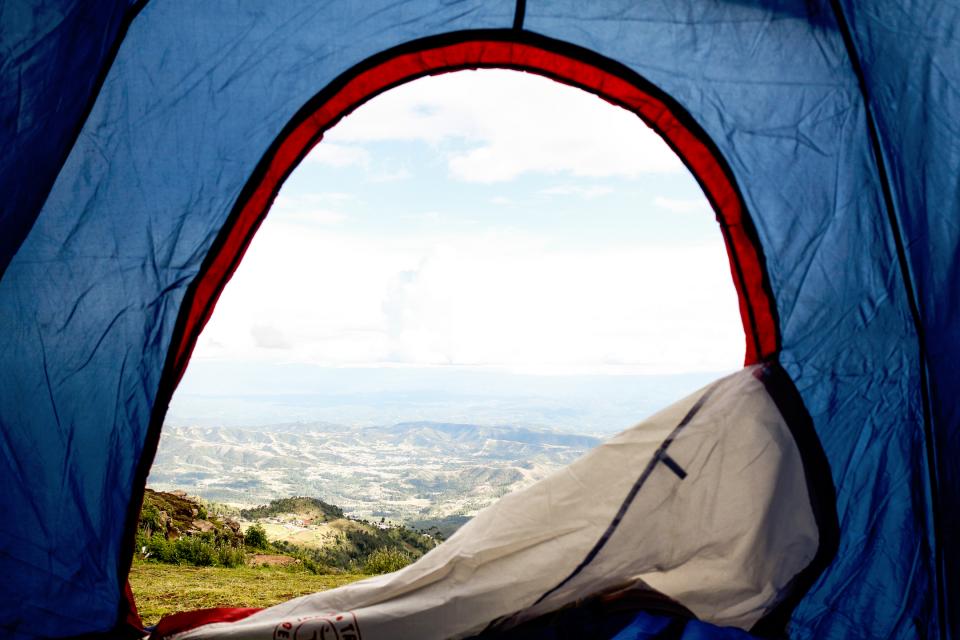 view of a hillside from the opening of a blue tent