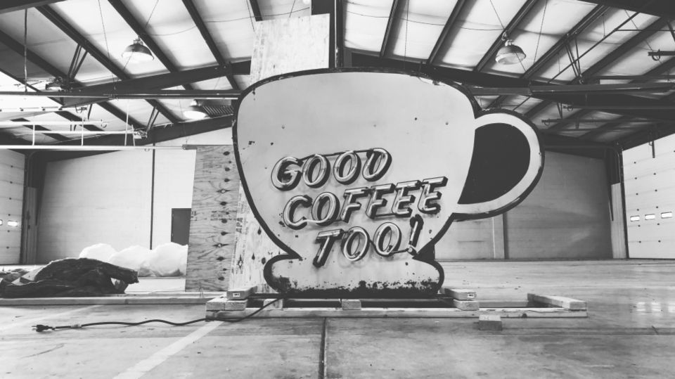 skeuomorphic coffee sign with neon letters that read "good coffee too!"