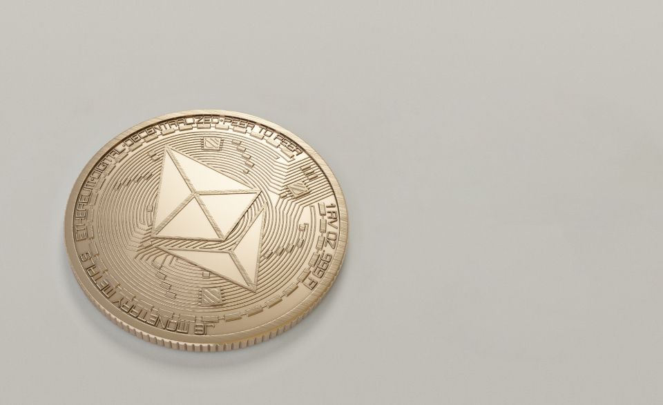 a gold physical bitcoin sits on a gray surface