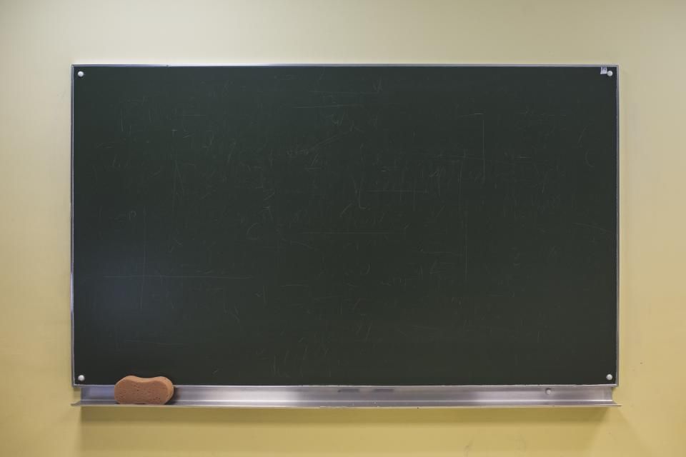 a blank chalkboard mounted on a wall