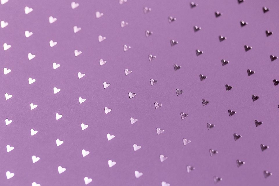 purple texture with small reflective, metallic hearts