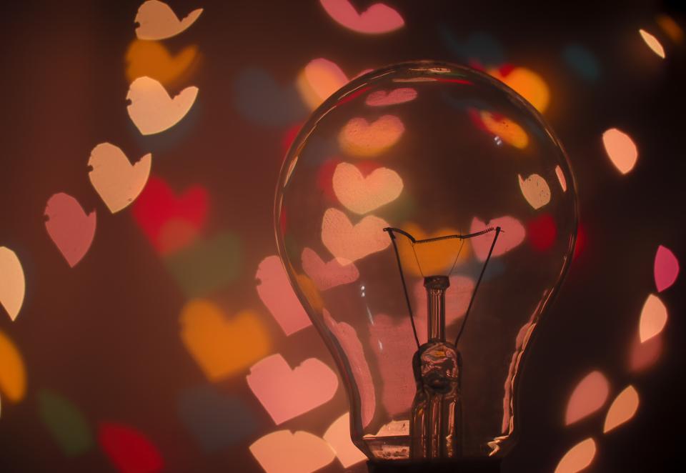 close up of edison lightbulb surrounded by multicolored bokeh lights