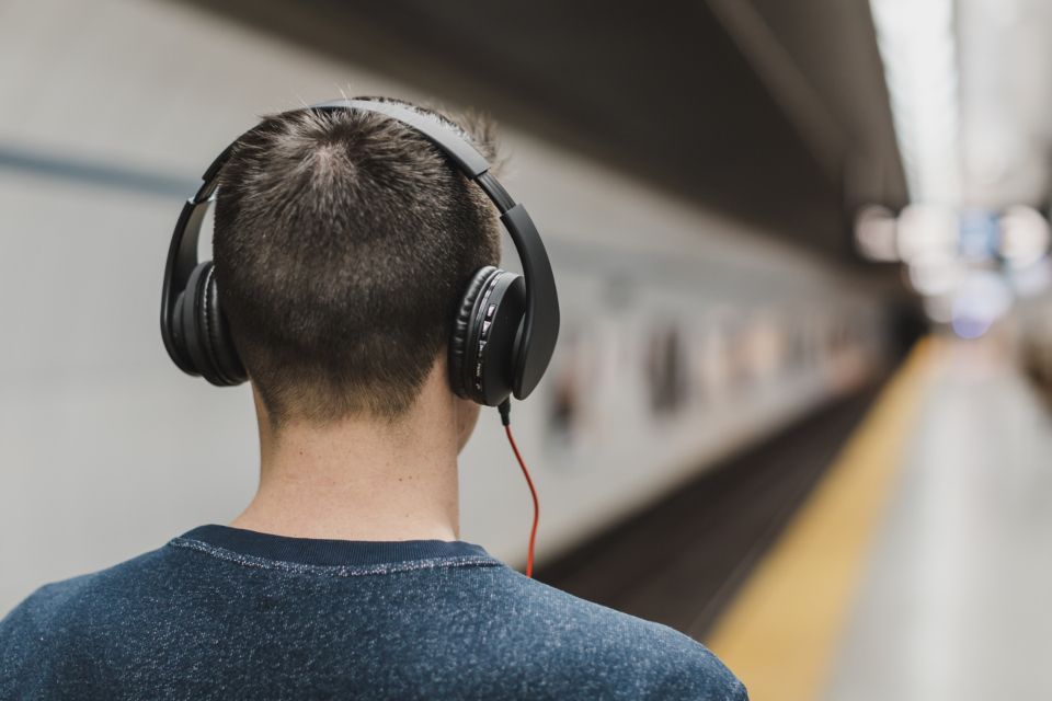 a person wearing headphones listens to music and walks in the subway station