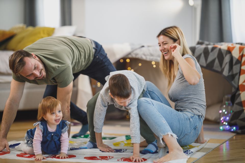 a family of four plays a game together in their living room