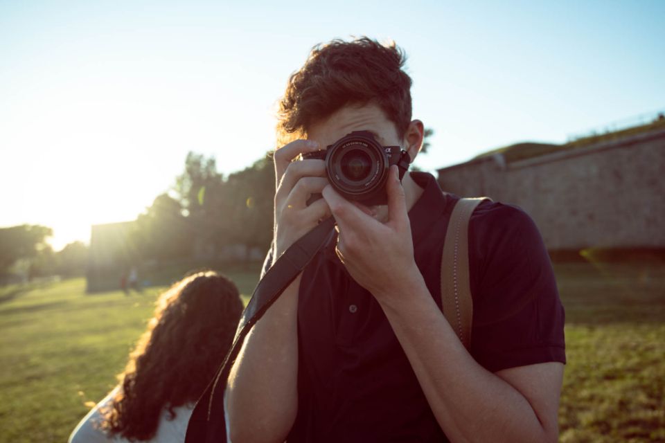 a photographer holds a camera on a sunny day
