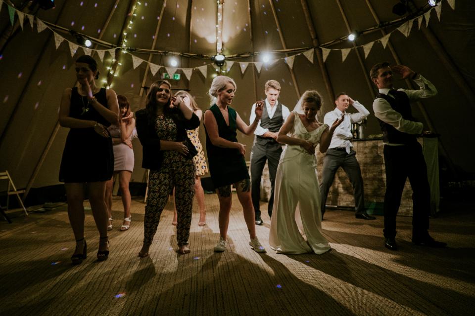 a bride and groom dancing with wedding guests by Mitchell Orr