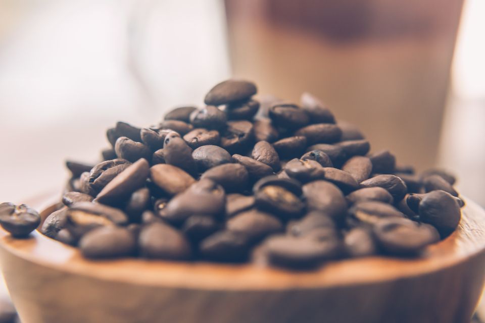 coffee beans sit in a wooden bowl