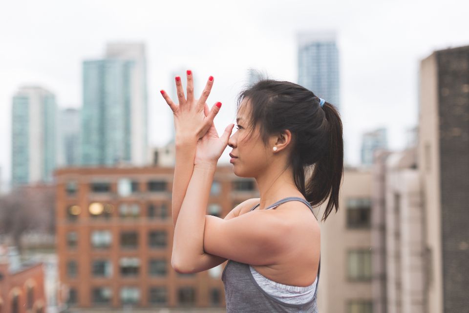 a woman practices yoga on a building's rooftop during the morning.