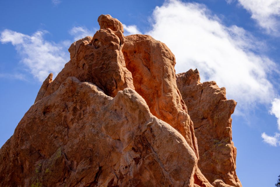 photograph of large red rocks set against the partially cloudy blue skies